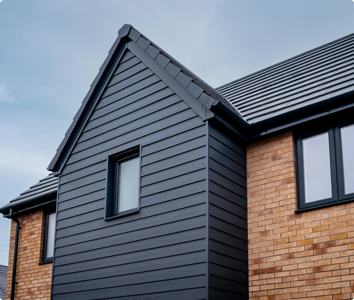 Black siding and brick facade