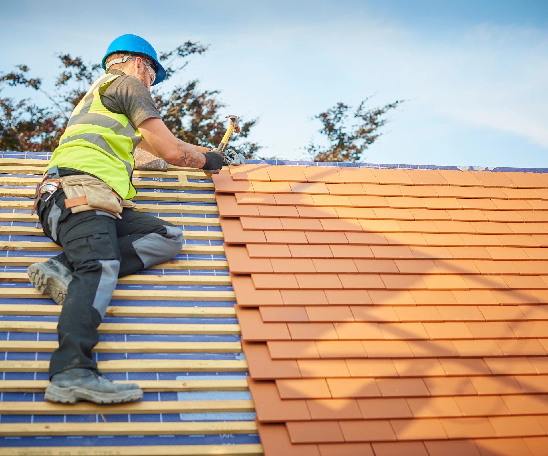Worker installing roof tiles